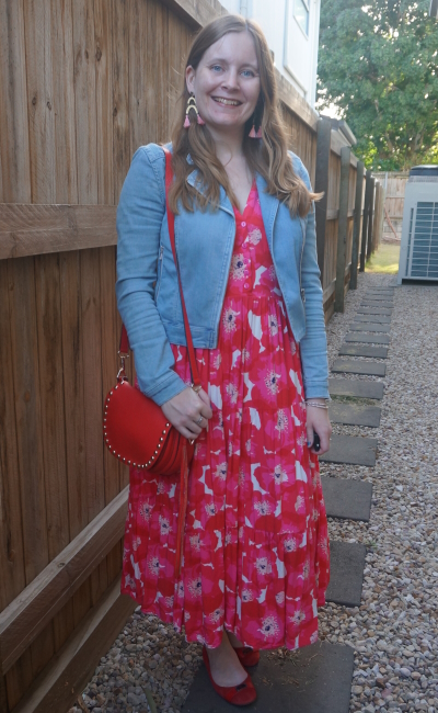 Cheerful mature female in denim jacket and red dress with bouquet of  flowers and straw hat smiling and looking away while standing on city  street Stock Photo - Alamy