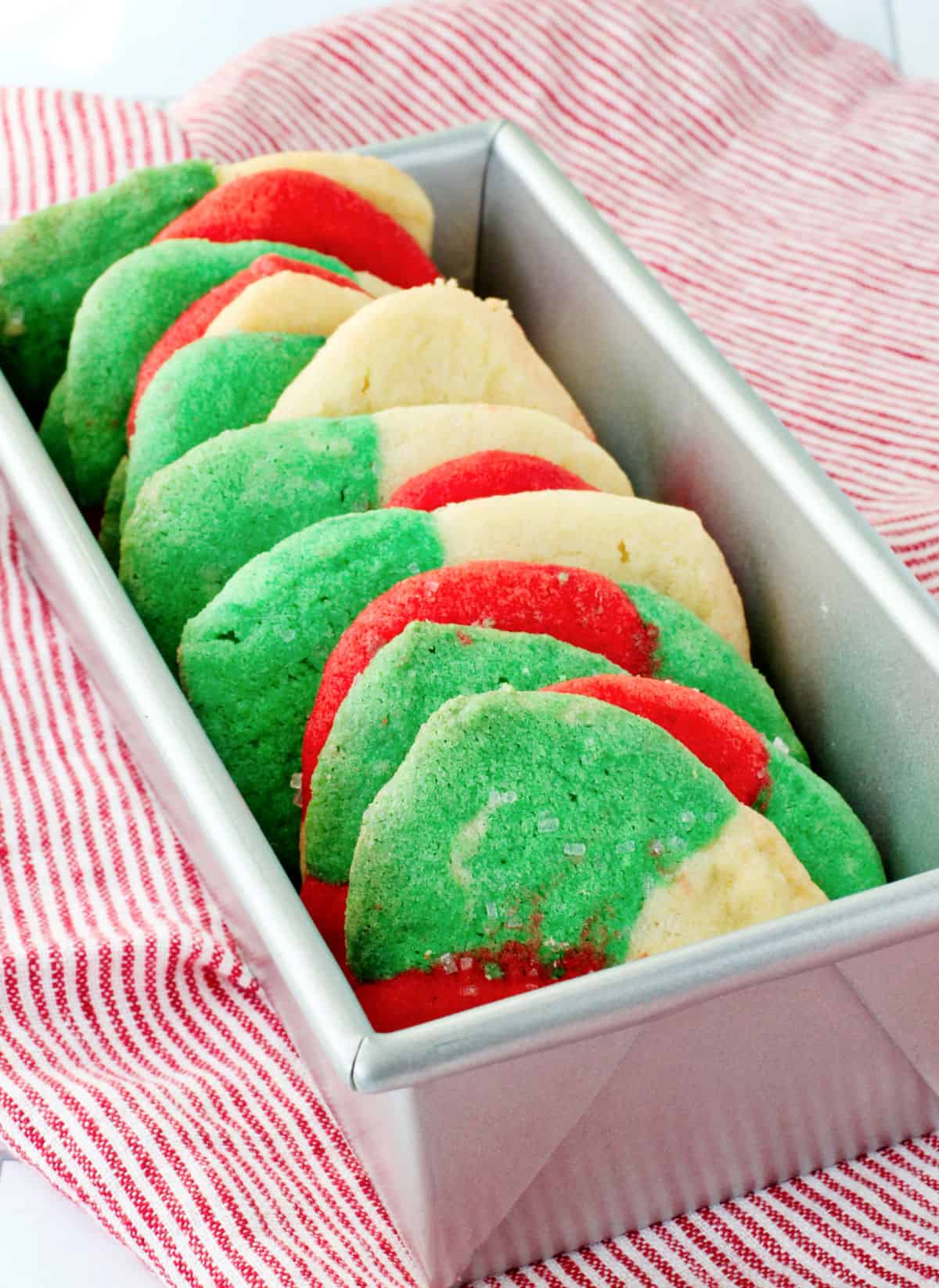 Red, White, and Green Polvorones (Mexican Sugar Cookies) in a bread pan.