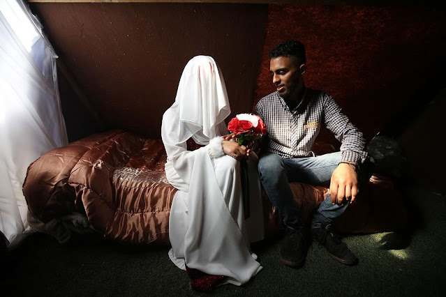 Palestinian newlywed Shaima Qazeet and Mahmoud Akhiziq inside a Rafah displacement camp by photographer Majdi Fathi