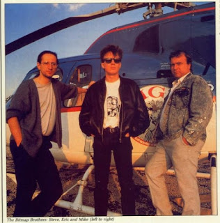 The Bitmap Brothers stand in front of a helicopter