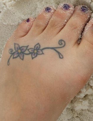 Thin curled branch with two flowers foot tattoo