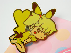 A pin badge of a girl cosplaying as pikachu 