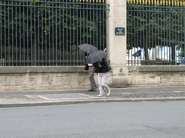 Umbrellas against the wind, rue de Rivoli, Paris