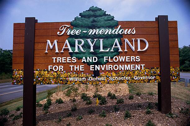 This is a road sign that says Tree-mendous Maryland, trees and flowers for the environment. It is the welcome to Maryland sign