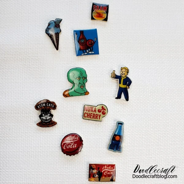 What are Enamel Pins?  Enamel pins are small, decorative pins typically made from metal and enamel.    They come in various shapes, sizes, and designs, often featuring colorful enamel coatings that are baked onto the metal surface.    These pins can depict anything from pop culture references to original artwork, and they're often collected and traded by geeked-out enthusiasts.   Enamel pins are commonly worn on clothing, such as jackets, hats, or bags, using a butterfly clutch or rubber backing to secure them in place.    They've gained popularity as a form of personal expression and as collectible items due to their affordability, versatility, and ability to showcase unique designs.