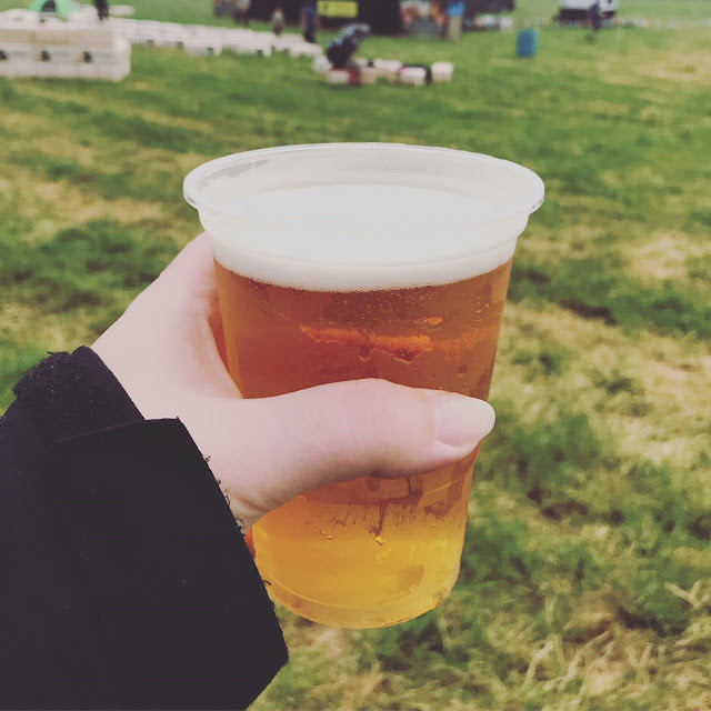 A hand holding a beer