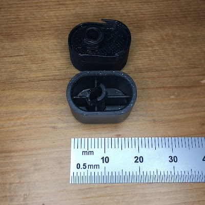 3D-printed power button (top) vs. original (bottom)