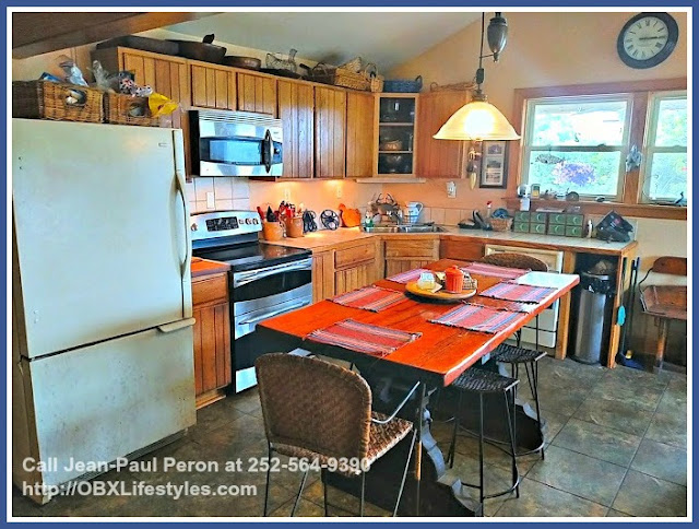 The kitchen of this stunning canal front home for sale in Corolla NC has plenty of shelves and cabinets. 