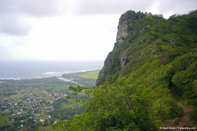 Dark rocky outcropping above a distant ocean coastline.