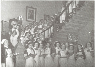 Photograph shows Adelaide Hospital nurses in uniform standing on the hospital staircase , 1950s