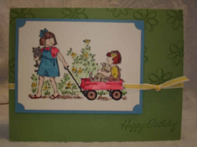 Little girl's birthday card with the image of one girl pulling a friend in a little red wagon.