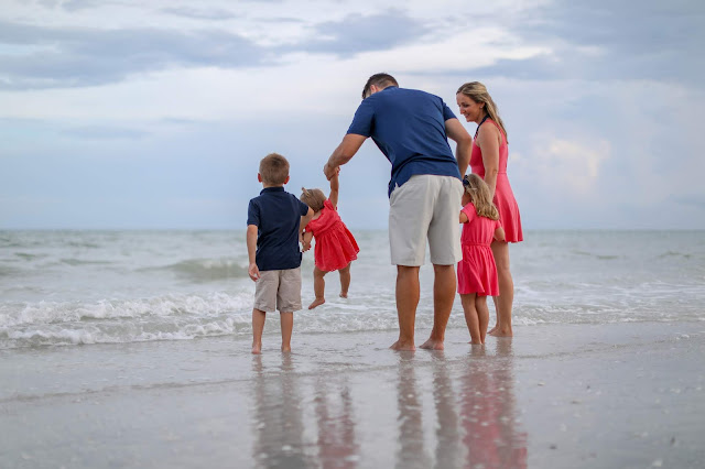 family walking in the water on sanibel