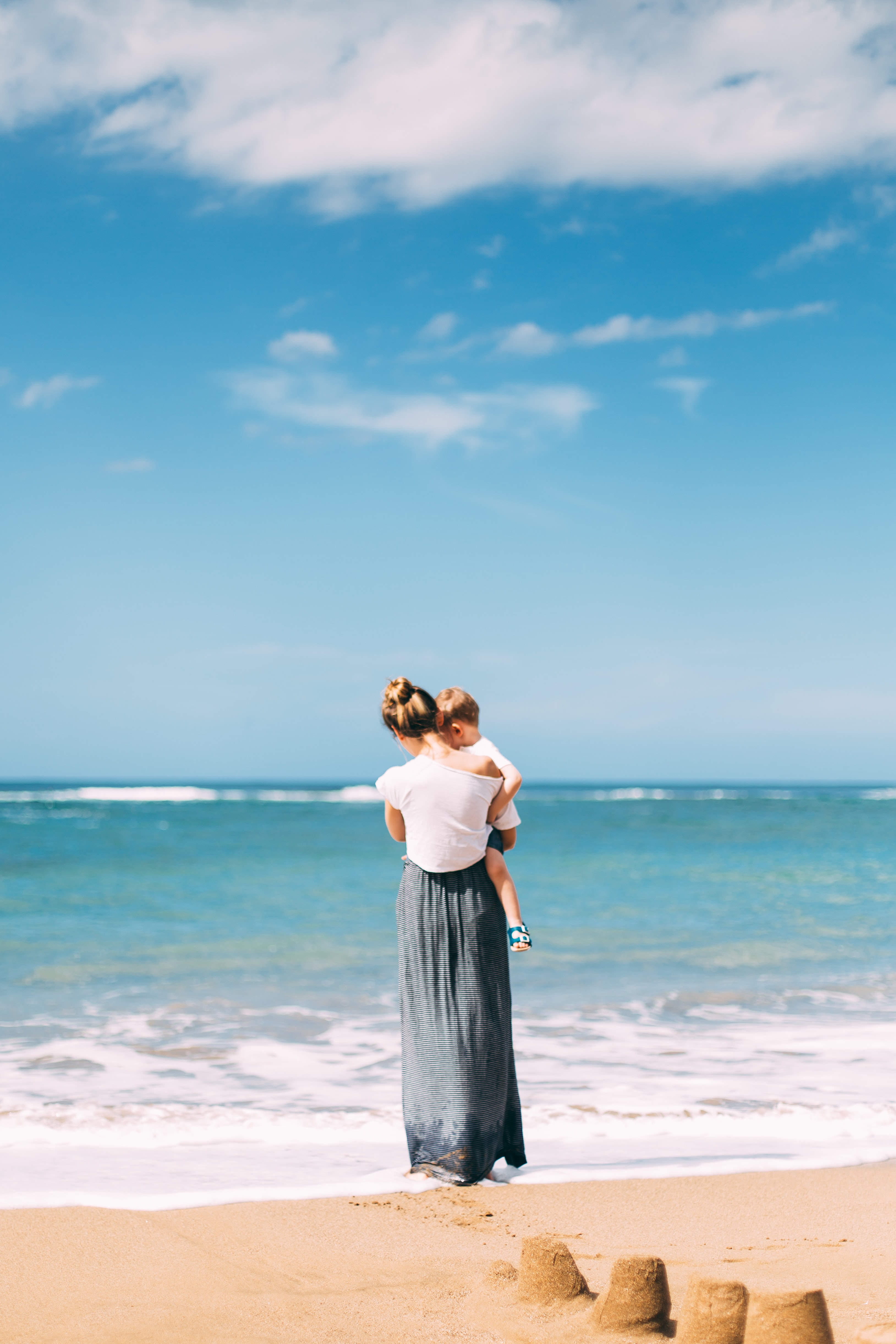 woman holdaing baby on beach