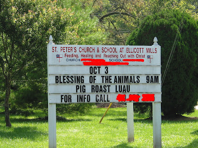 church sign advertising a Blessing of the Animals service and a pig roast luau