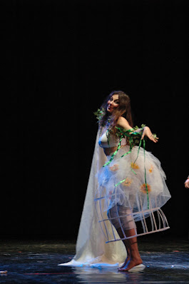 Danza Dea Madre Ispirato al testo “Aradia – Il Vangelo delle Streghe” di C. G. Leland nella traduzione curata da Lorenza Menegoni. Tre danzatrici, due attrici ed una cantante interagiscono in scena utilizzando una pluralità di linguaggi espressivi che si animano da una installazione "cosmogonica" da cui si dipana la performance. Il linguaggio coreutico dell’"etnico" viene fortemente decontestualizzato e modernizzato per veicolare messaggi universali, aldilà di qualsiasi legame spazio-temporale. Personaggi: La grande Sacerdotessa, La Fata Incantata, Le Colonne del Tempio, La Strega, La Voce del Bosco Sacro “In Principio……” Come in tutte le Cosmogonie sacre, dal Buio Primordiale si genera la Luce. Le due Colonne del Tempio, simbolo di tutte le dualità create, danzano schiena a schiena, come nel primo capitolo della Genesi, ed avviene il primo atto di ogni vivente: riconoscere l’”Io” dall’”Altro”. Nasce l’ ”Io sono”. Alarippu, la prima danza, è dunque il risveglio del corpo della danzatrice, svelata gradualmente come l’alba che sta per nascere. La danza successiva, su un testo medioevale di Raimondo Lullo, inneggia al sorgere del sole nei più puri modi della letteratura cortese. Il tema dell’Amore di Separazione ci ricorda che in ogni nascita c’è distacco. Echeggia dunque l’invocazione alla Grande Dea in un bosco incantato, in un carillon fatato e in un cerchio sacro, mentre brani estratti dal repertorio indiano, diffondono i loro messaggi di Amore e Gioia. Ritorna infine la Notte, si spengono le luci; lo spettacolo è quindi come un giorno, una vita, un’era, un rito. Omaggio ad una sacralità tutta al femminile, archetipica ed universale. A. Migliorini (Danza Classica Indiana Bharata Natyam), M. Sales (Danza Mediorientale e sue interpretazioni contemporanee) - L. Raciti - Katya Sanna (per gentile concessione Compagnia Nuove Indye) - A. Migliorini, M. Sales, Paola Stella - Giovanna Genovese, Camilla Triolo