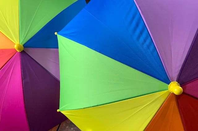 Two open rainbow umbrellas