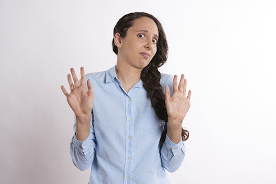 Woman in a blue shirt looking scared