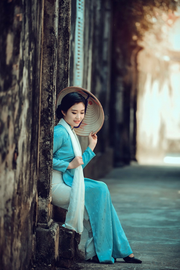 Thiếu nữ ngồi áo dài xanh nón lá