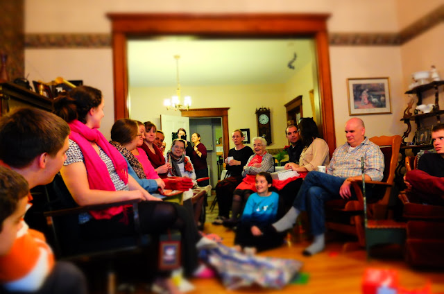 family members crowded into a living room listening and talking