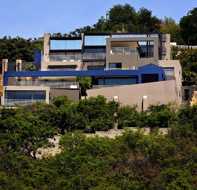 Picture of the mansion up on the hill surrounded by green vegetation