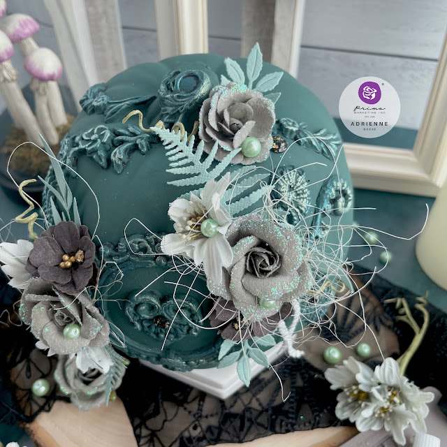 Dark green altered pumpkin with a dark academia aesthetic using moulds, flowers, pearls and gems from Prima Marketing Inc. (Lost in Wonderland, Twilight and The Plant Department Collections); Frank Garcia Memory Hardware; and Finnabair moulds, paint and wax.
