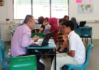 Parent Teacher conference with student at a table.