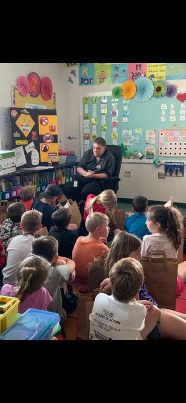 elementary students listening to a sheriff