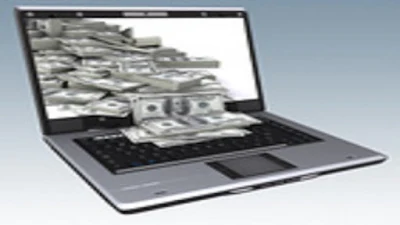 A lone computer with dollar notes spilling out from the screen.