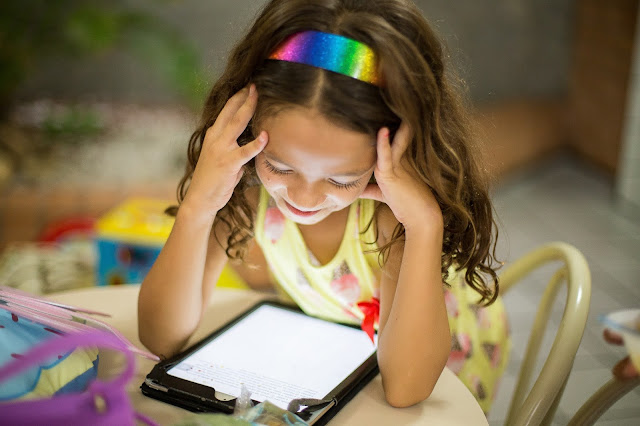 Young girl with a smile, at home staring at a screen