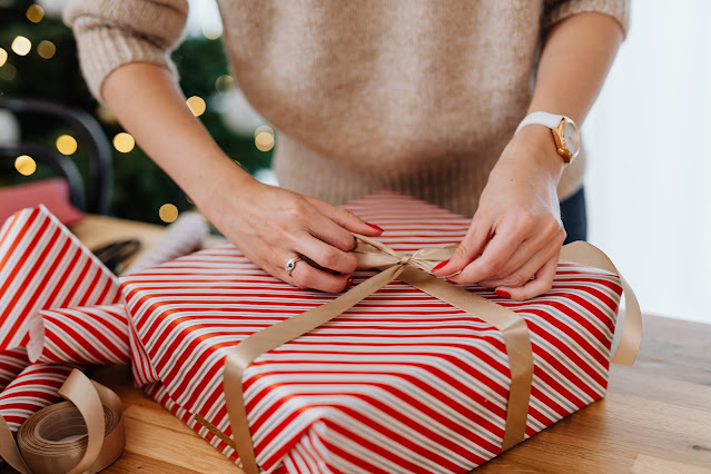 person wrapping Christmas gift