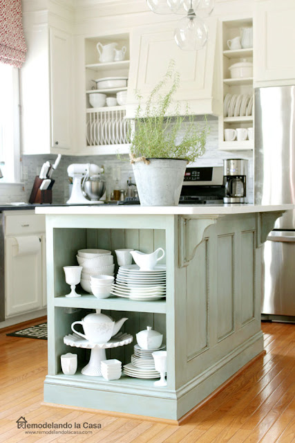 white kitchen with blue kitchen island with white chine on the shelf
