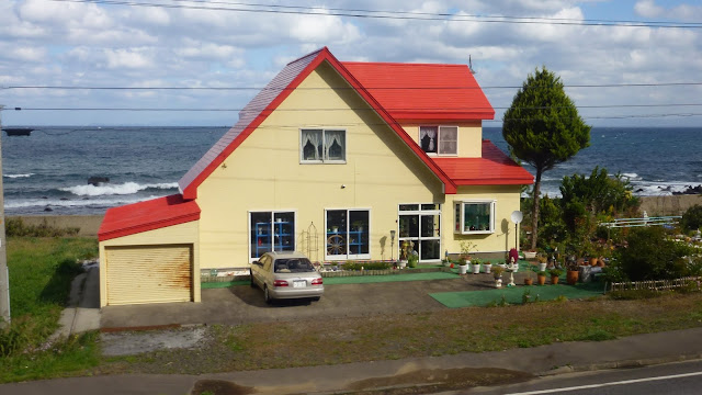 Yellow house with red roof by the sea