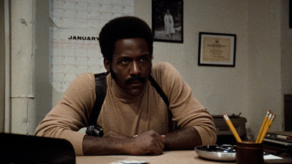 Richard Roundtree as John Shaft sitting at a desk not ready to take any shit today