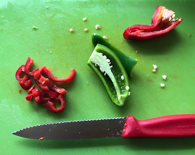 Pepper halves and knife on cutting board