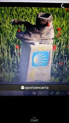 uma bota de caminhada em cima de um marco do Caminho de Santiago com a legenda oportoencanta