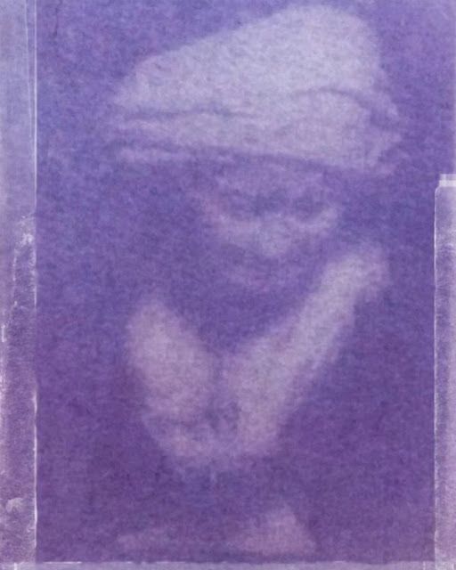blurry violet-toned photograph of slightly smiling woman paper sculpture