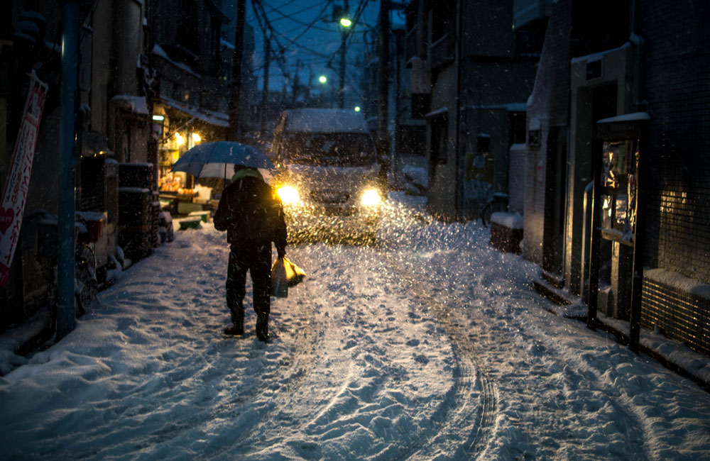 夜、吹雪の中帰宅している写真