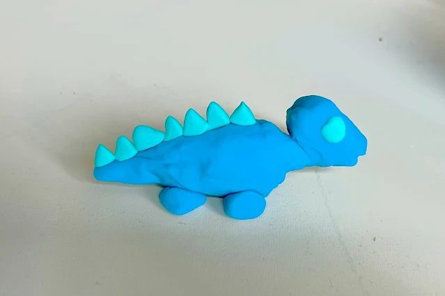 A blue dinosaur model made from modelling clay