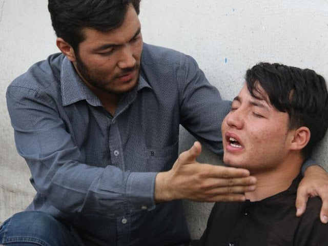 An Afghan resident (R) weeps for his relative following a suicide attack in Kabul