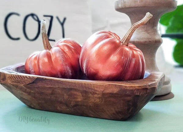 copper pumpkins in wood bowl