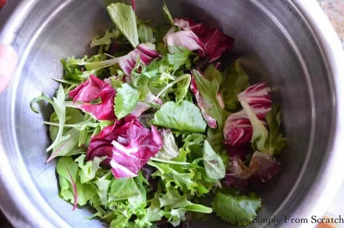 A down shot of Mixed Baby Salad Greens in a stainless steel bowl.