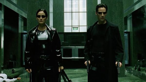Trinity and Neo wearing black leather coats in the lobby in The Matrix