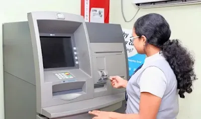 A person using an ATM in a well-lit environment, emphasizing the importance of ATM safety