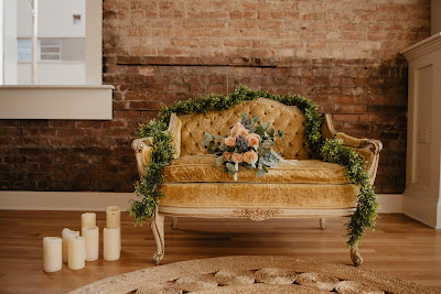 Velas junto a un sillón decorado con flores