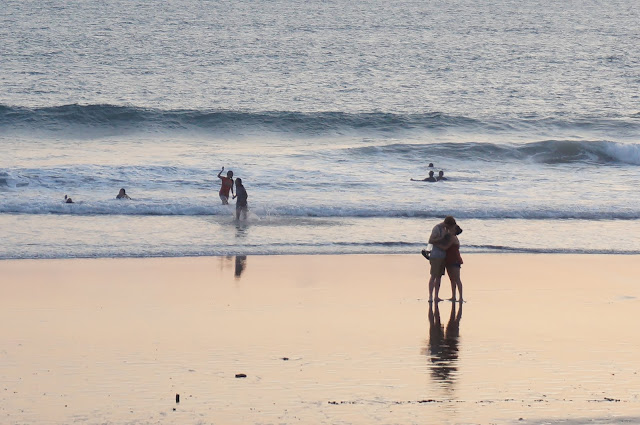 Two lovers kiss at the beach during sunset in Canggu, Bali, Indonesia