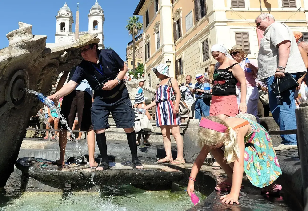 Persone si bagnano con l'acqua delle fontane