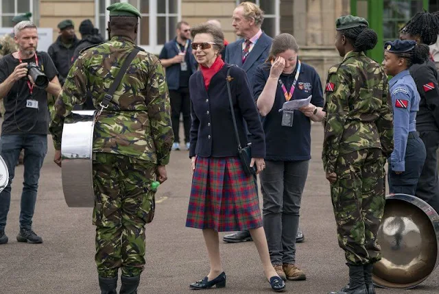 Princess Anne wore a red tartan skirt and navy black jacket. Gold earrings