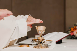 Priest with hands over the chalice