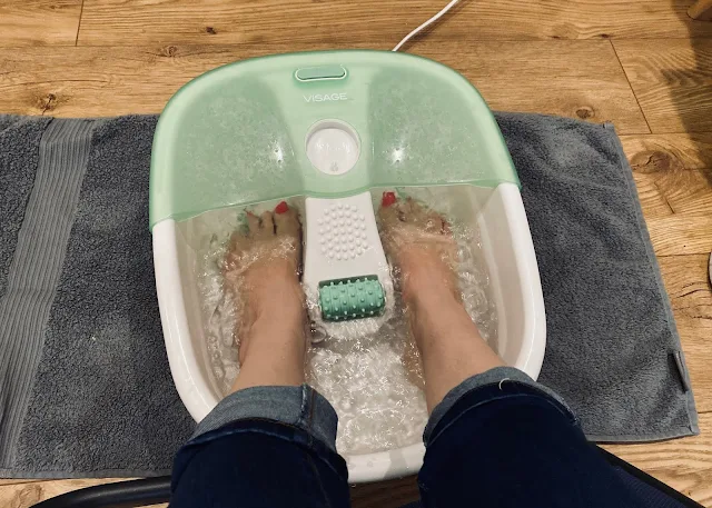 Feet in a foot spa before reflexology treatment