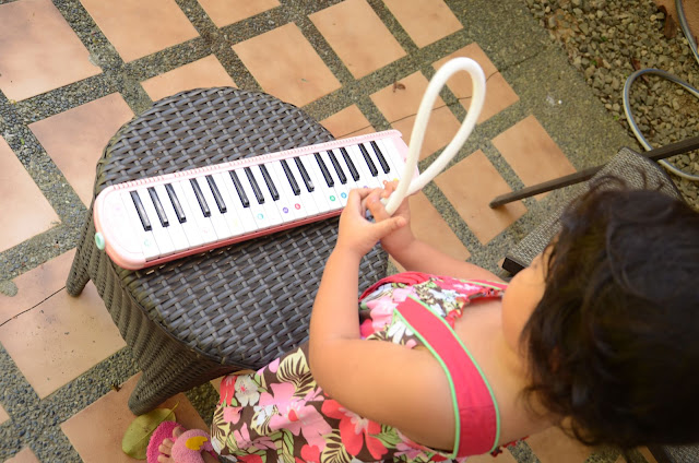 Kecil trying to fix the pianika's mouthpiece